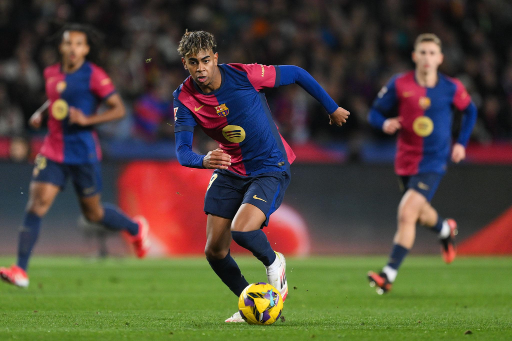 Barcelona winger Lamine Yamal dribbles past an opponent during a football match.